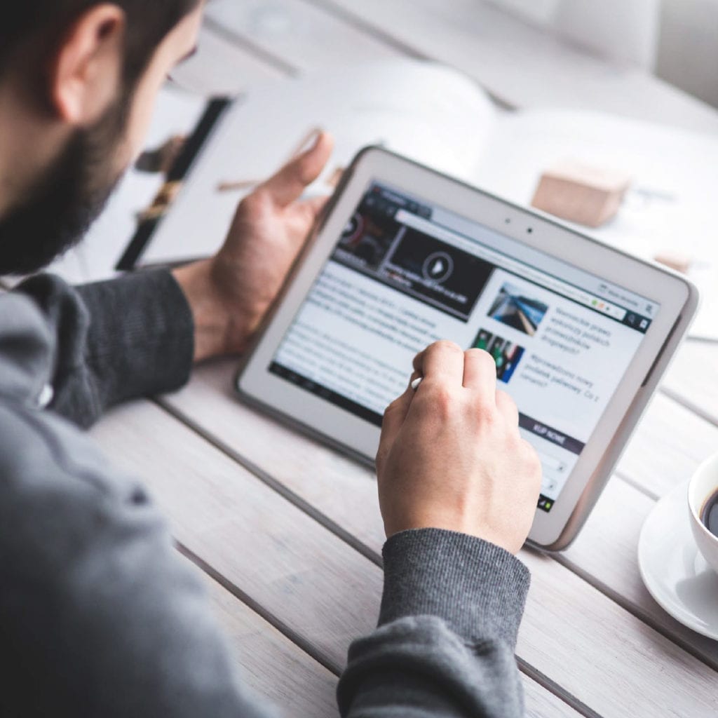 Man holding tablet looking at new modern website design