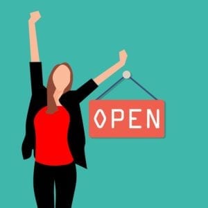 Confident business woman beside open sign - ideal customer